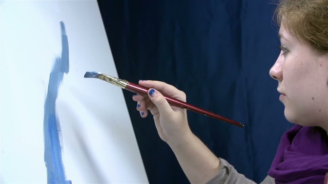 Girl starts drawing something on canvas