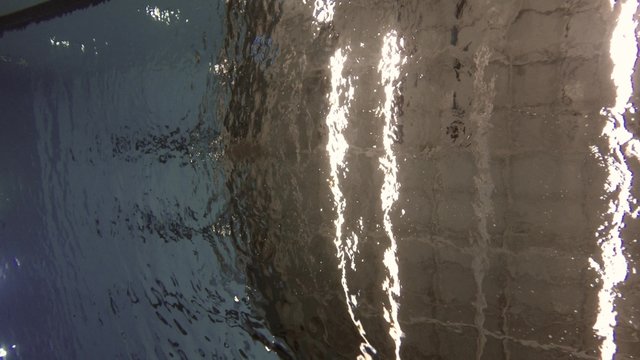 Underwater shot of swimming pool surface with ceiling