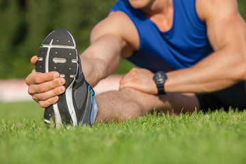 Fit healthy athlete is doing warm-up in stadium
