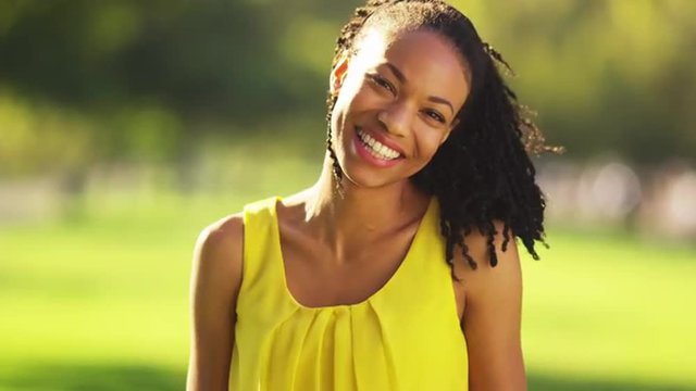 Happy black woman smiling in a park