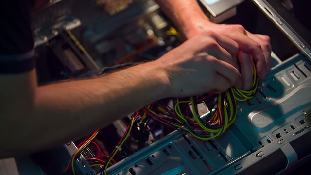 Medium shot of man wiring personal computer