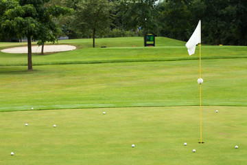 Obraz premium White flag on a golf course, focus on the flag