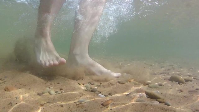 Feet walking underwater dollyshot