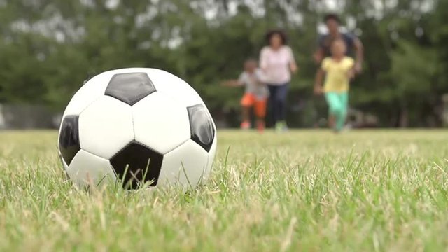 Slow Motion Sequence Of Family Playing Soccer In Park 