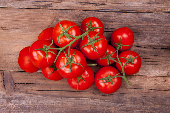 Bunch of tomatoes on vine shot from above on a wooden background