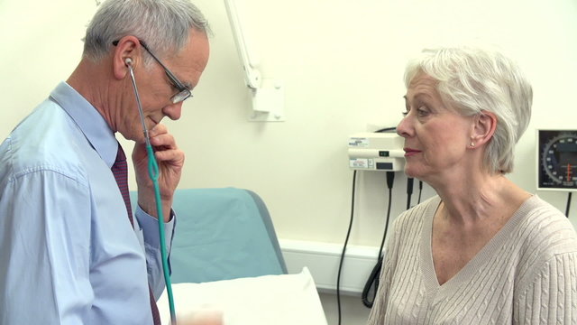 Doctor Listening To Senior Female Patient's Chest
