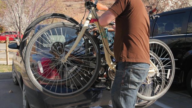 Man strapping a bike on the bike rack