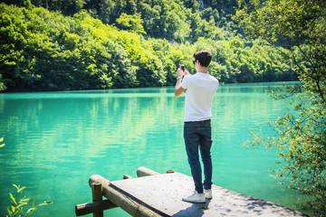 Rear View of Young Man Taking Photos at the Beach