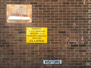 Fototapeta na wymiar Parking warning signs on red brick wall