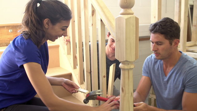 Mature Students In Carpentry Class Working On Staircase