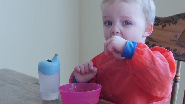 A toddler eating his breakfast