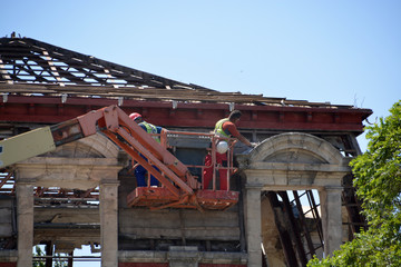 obrero trabajando sobre una grua derribando un edificio