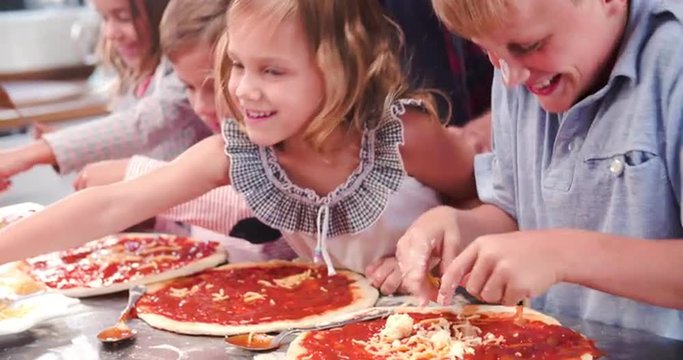 Family Making Pizza In Kitchen Together