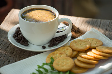 Cup of coffee on a wooden board and biscuits
