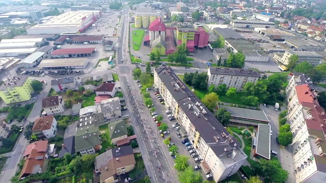 Group of cyclists driving through city streets aerial shot