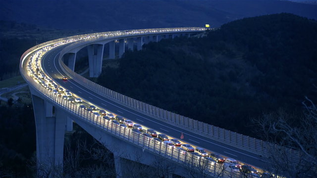 Car vehicles driving at night on long bridge