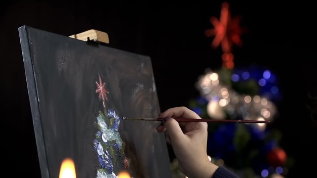 Hand drawing a Christmas tree on canvas