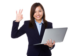 Young businesswoman use of the laptop computer and ok sign gestu