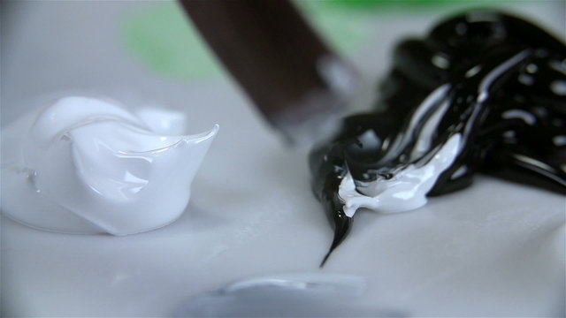 Mixing white and black acrylic color on palette