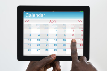 Person Using Calendar Application On Digital Tablet