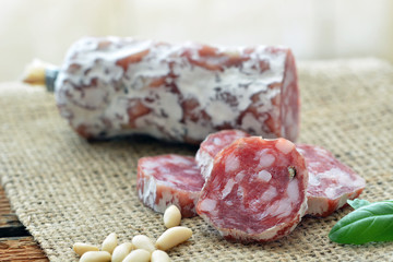 Salami (Rohwurst), auf Jute, Pinienkerne, Basilikum