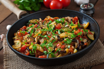 Vegetable Ratatouille in frying pan on a wooden table