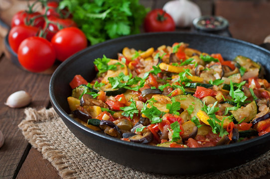 Vegetable Ratatouille in frying pan on a wooden table