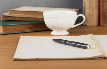 old notebook with pen on wood table