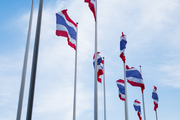 Thai flags waving under blue sky