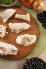 Raw pig tails on wooden background