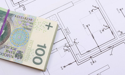 Heap of banknotes on electrical construction drawing of house