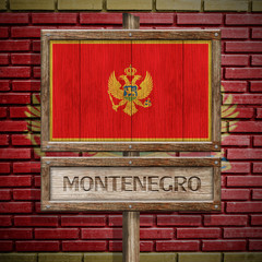 Montenegro flag wooden sign with brickwall background
