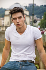 Handsome young man in white t-shirt outdoor in city