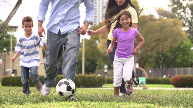 Slow Motion Shot Of Hispanic Family Playing Soccer Together