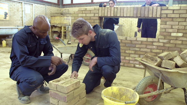 Teacher Helping Students Training To Be Builders