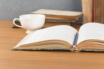 old book with pencil and coffee