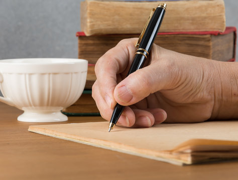 Hand writing a notebook on table