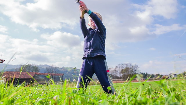 Kid slicing through grass with sword in slow motion