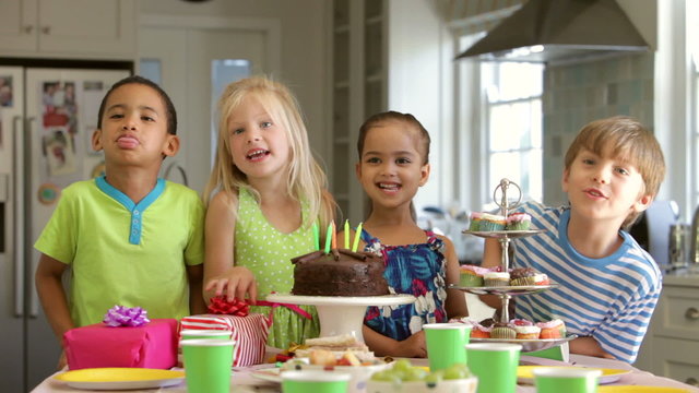 Group Of Children Celebrating Birthday With Cake And Gifts