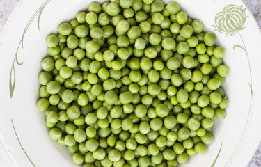Green peas on the white plate background
