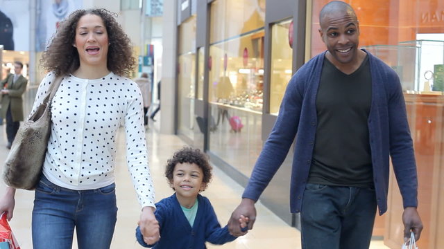 Child On Trip To Shopping Mall With Parents