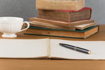 old notebook with pen on wood table