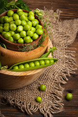 Fresh organic green peas on a wooden background. Rustic style.
