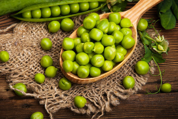 Fresh organic green peas on a wooden background. Rustic style.