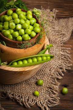Fresh organic green peas on a wooden background. Rustic style.