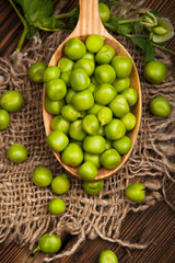 Fototapeta na wymiar Fresh organic green peas on a wooden background. Rustic style.