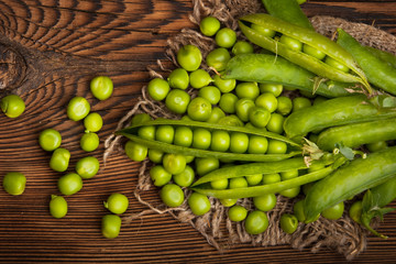 Fresh organic green peas on a wooden background. Rustic style.