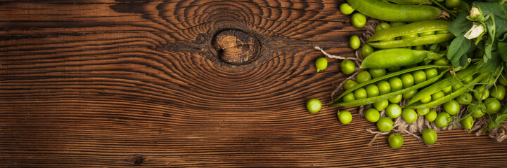 Fresh organic green peas on a wooden background. Rustic style.