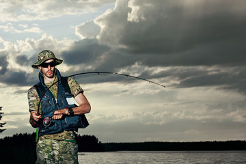 Surprised man fishing on the lake during sunset outfit of a fish