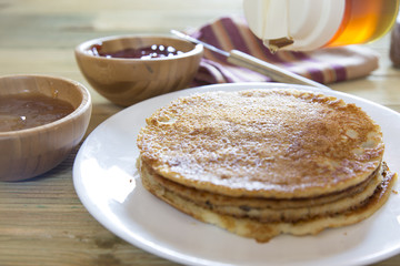Honey pouring over a stack of mini pancakes